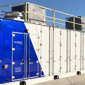 A large industrial container with a blue and white design labeled 'Fluence' and the number '111'. It has multiple doors and is situated outdoors under a clear blue sky.