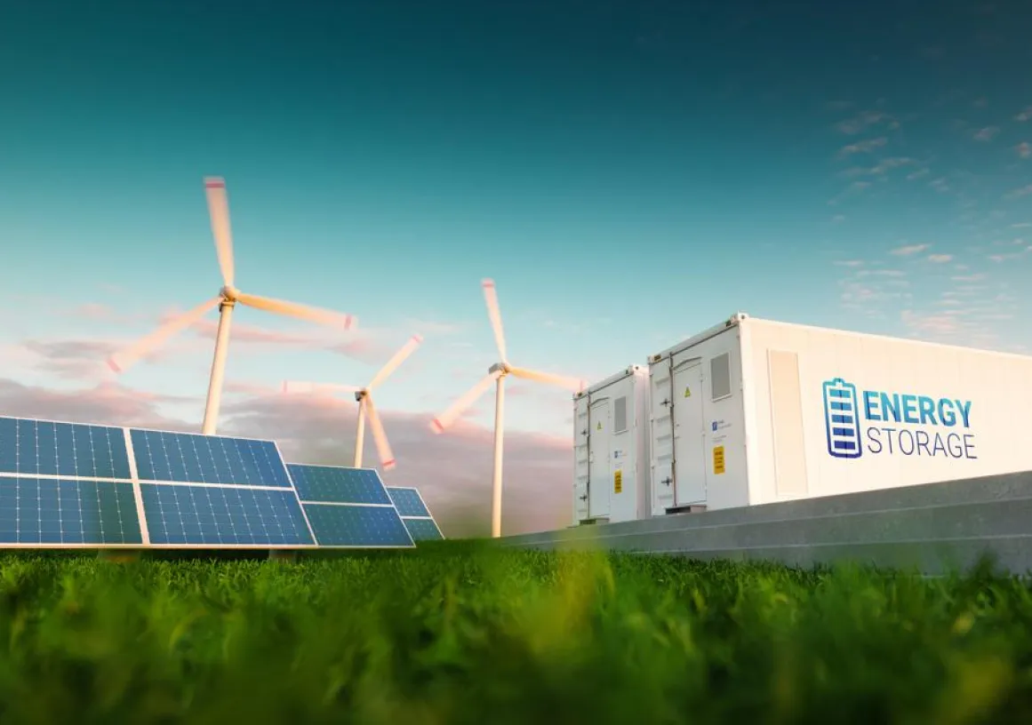 A landscape featuring solar panels, wind turbines, and a white container labeled 'Energy Storage' on a grassy field under a blue sky.