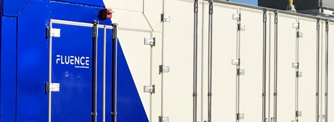 A large industrial container with a blue and white design labeled 'Fluence' and the number '111'. It has multiple doors and is situated outdoors under a clear blue sky.