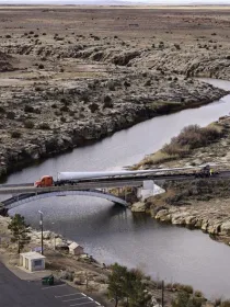 semi-truck-crossing-bridge-over-river-in-desert-west-camp-2.jpg