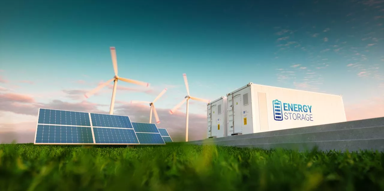 A landscape featuring solar panels, wind turbines, and a white container labeled 'Energy Storage' on a grassy field under a blue sky.
