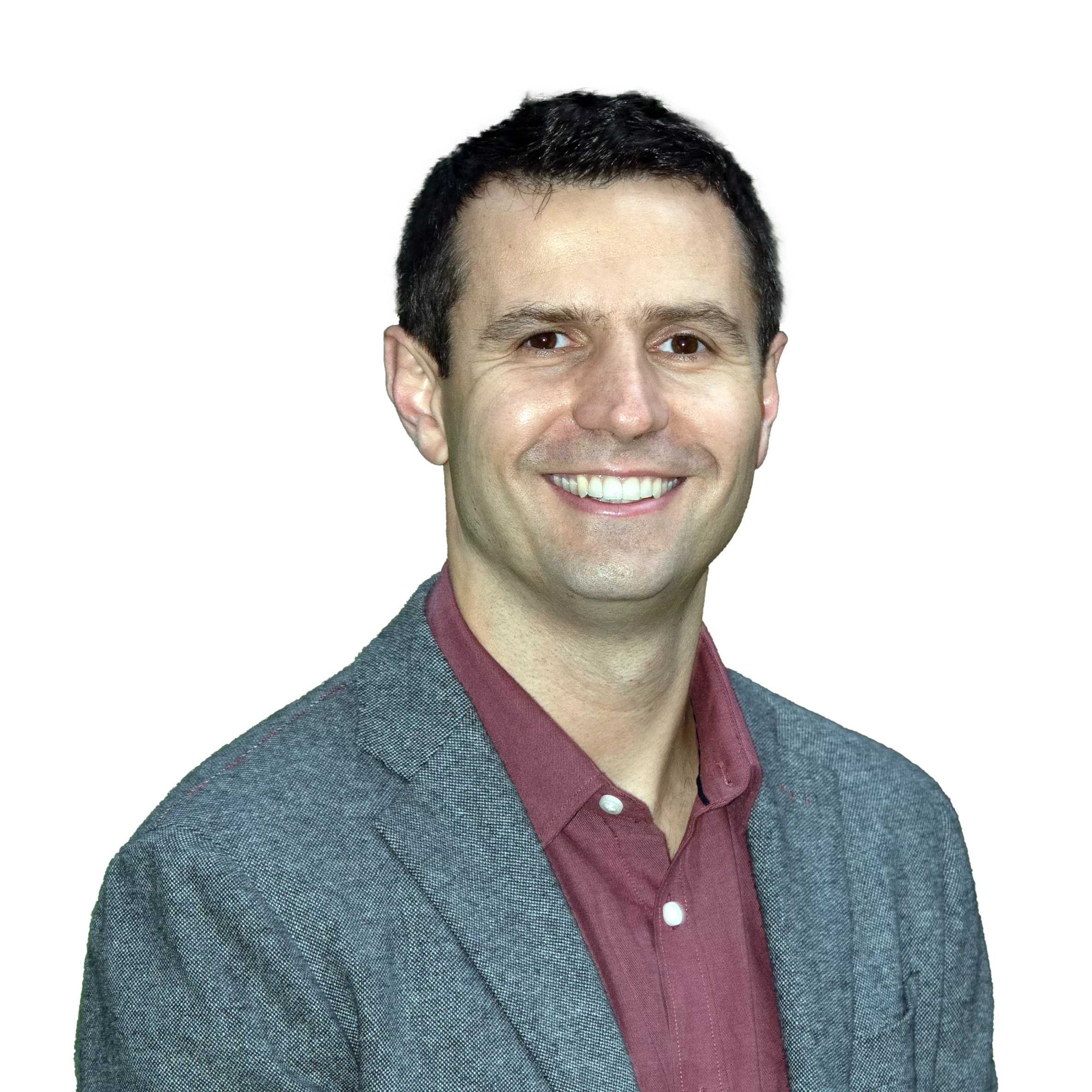 A man with short dark hair, smiling, wearing a gray blazer over a maroon shirt, against a plain background.