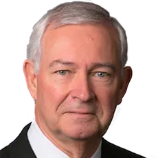 Portrait of an older man with gray hair and a suit, looking directly at the camera.