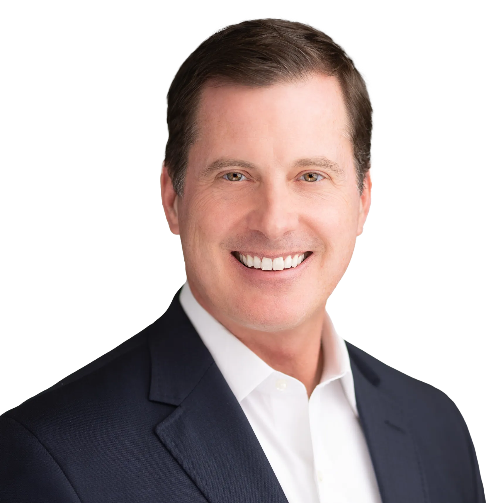 Stephen Coughlin headshot. Smiling man with short brown hair wearing a dark suit jacket and white dress shirt, posing against a plain light background.